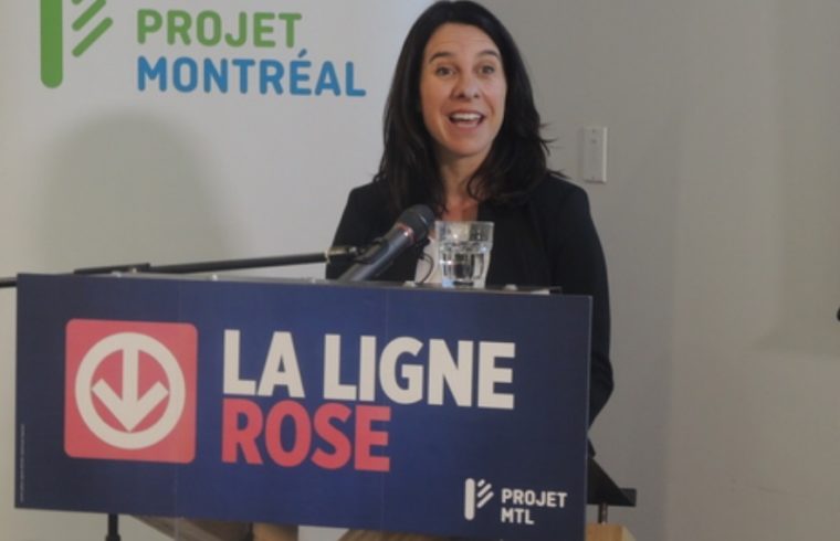 Une femme debout devant un podium avec les mots « la ligne rose » lors d'Élections Montréal, s'assurant que les critères d'embauche soient respectés.