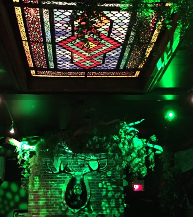 Au Saint-Moose, les invités peuvent déguster leurs cocktails et leurs entrées tout en admirant le fascinant plafond de vitraux verts.