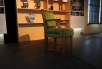 Une chaise verte devant une bibliothèque du Musée.