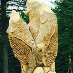 Une sculpture en bois représentant un loup et une tête de loup, représentant l'essence de la nuit et des loups.