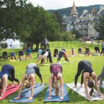Un groupe de personnes pratiquant le yoga pose devant un bâtiment lors d'une séance paisible et sereine de Wanderlust.