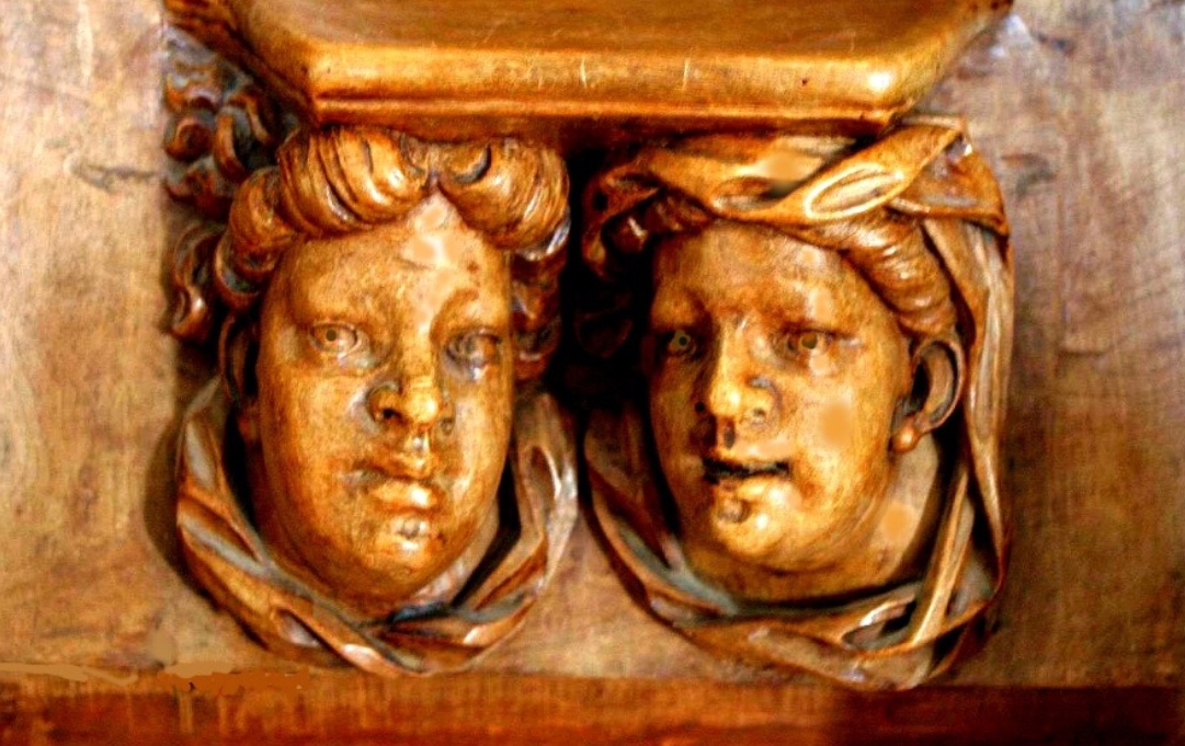 Une sculpture de deux visages sur une étagère en bois, déguster