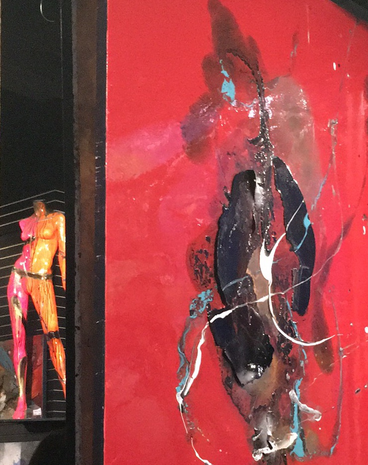 L'expérience artistique de Lisabel met en valeur une peinture saisissante représentant un mannequin rouge magnifiquement présenté dans un cadre en verre.