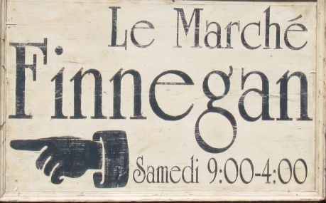 Une enseigne traditionnelle en bois qui affiche fièrement l'attrait du « Marché Finnegan ».
