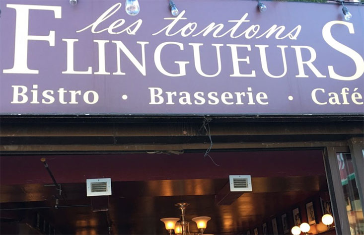 L'enseigne des Tontons Flingeurs, une brasserie française, se trouve sur le côté d'un immeuble à Montréal.