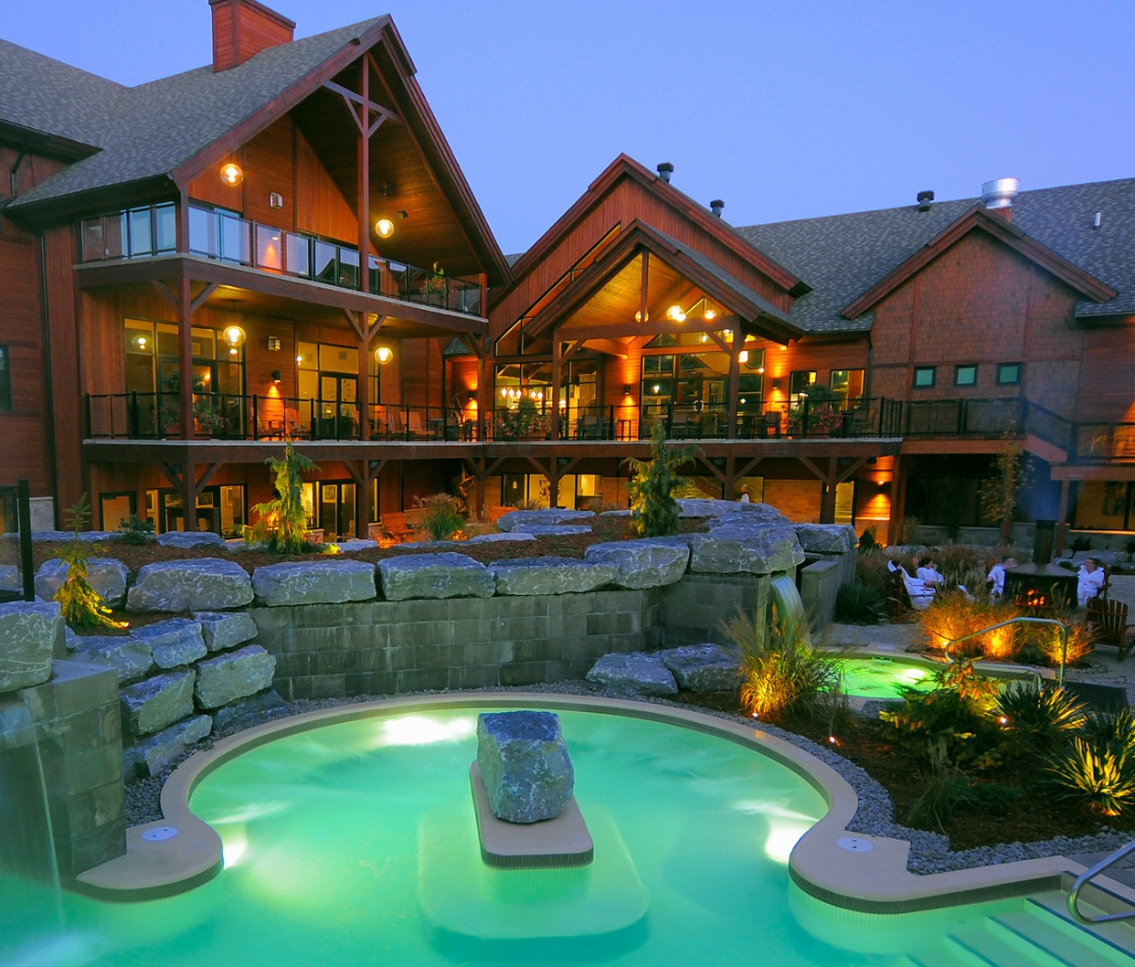 Un spa Kinipi nordique offrant un séjour agréable avec une piscine dotée d'une cascade relaxante.