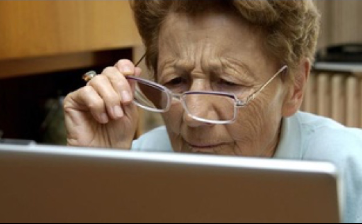 Une femme âgée navigue sur Internet sur un ordinateur portable.