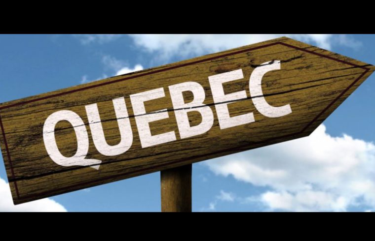 Une pancarte en bois avec le mot Québec dessus.