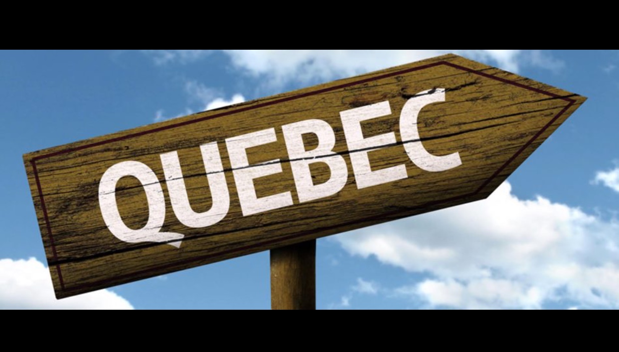 Une pancarte en bois avec le mot Québec dessus.