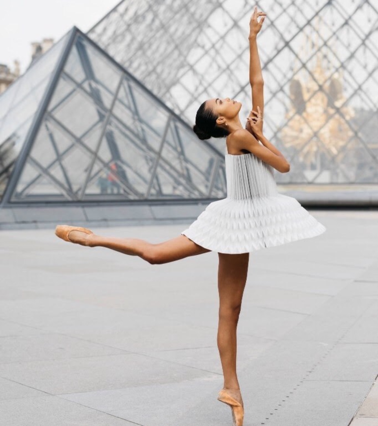 Miss Cloudy, danseuse de ballet, se produit avec grâce devant le Louvre.