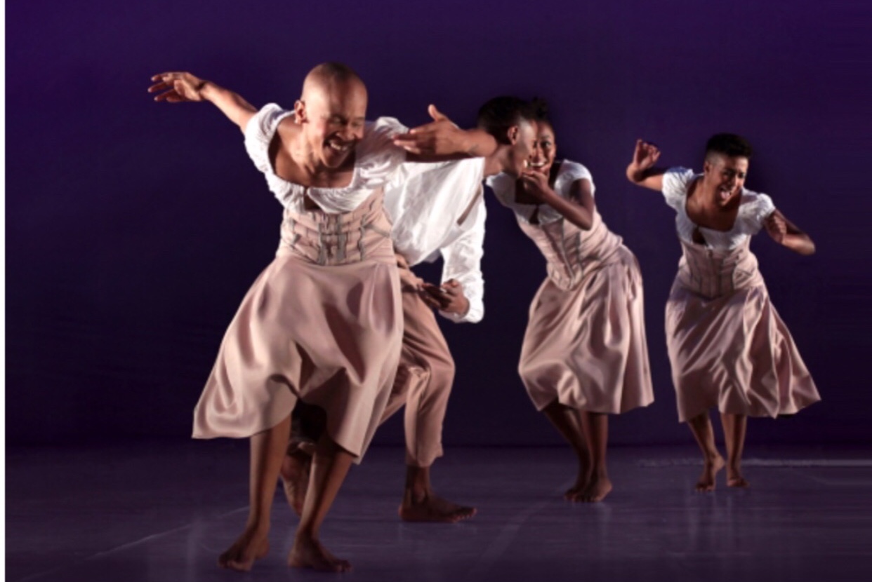 Une troupe de danseurs exécutant une danse inspirée sur une scène violette captivante.