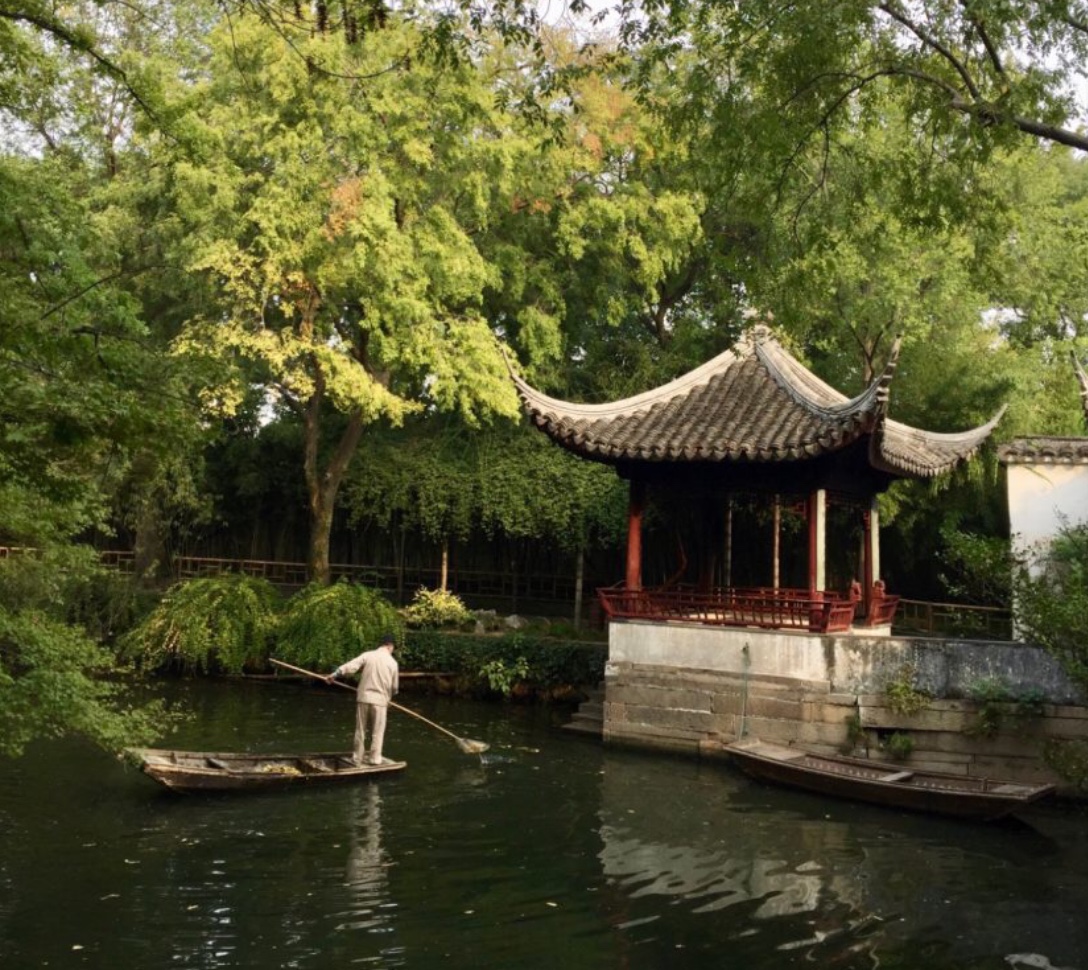 Un homme dans un bateau dans un jardin chinois.