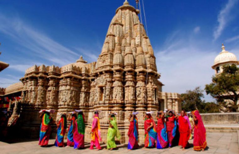 Femmes en saris colorés debout devant un temple en Inde.