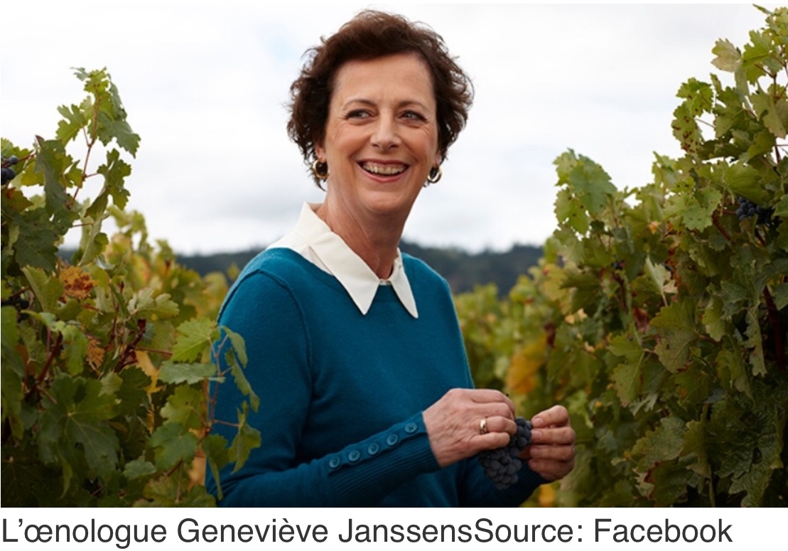 Une femme se tient debout dans un vignoble avec des vignes de Pinot noir en arrière-plan.