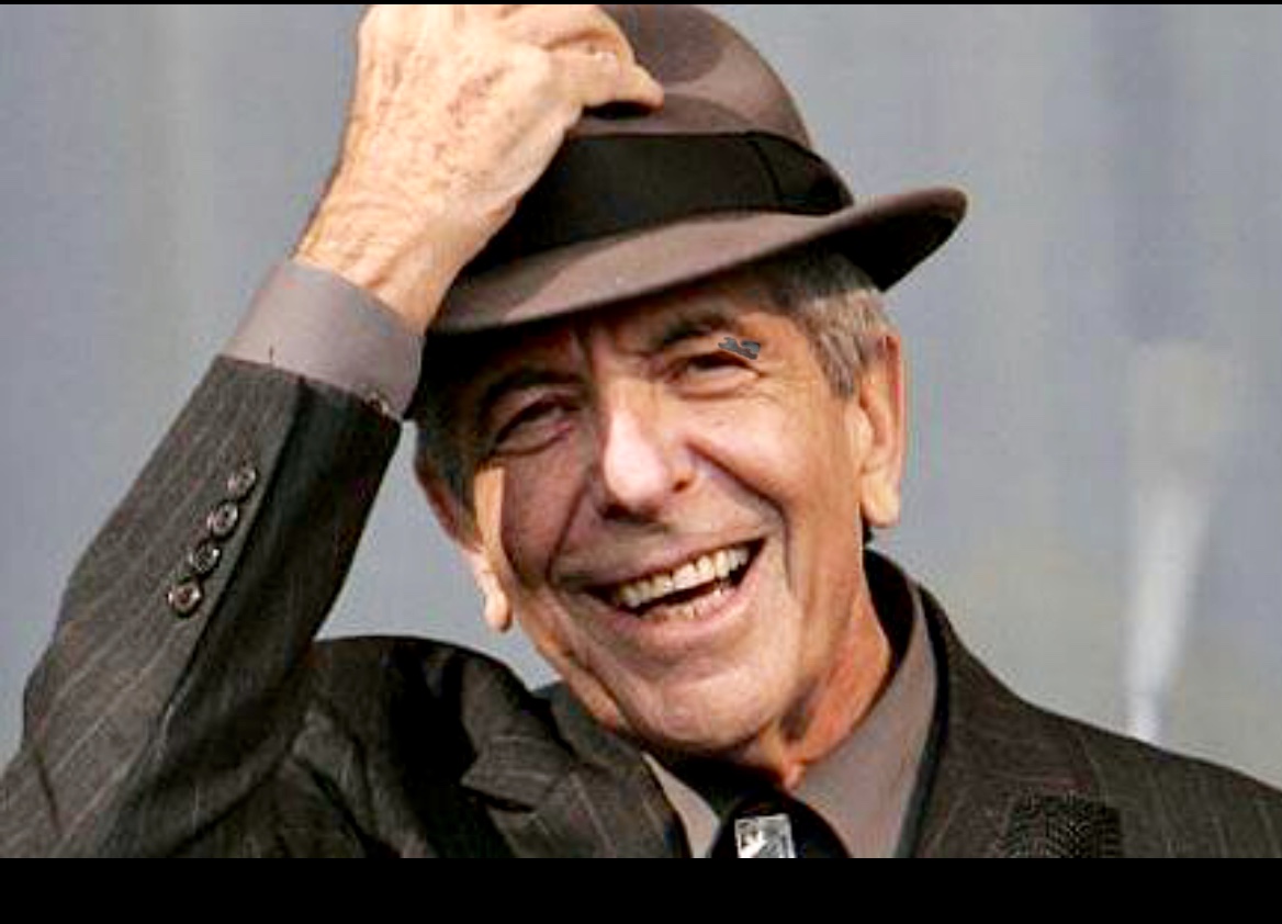 Leonard Cohen, un homme au chapeau, sourit.