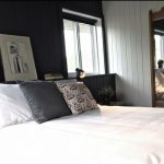 Une chambre en noir et blanc d'inspiration Beatnik Hôtel avec un lit et un miroir.