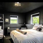 Un lit superposé style Beatnik Hôtel dans une chambre aux murs noirs.