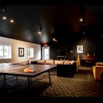 Un salon inspiré du Beatnik Hôtel avec une table de ping-pong et des canapés.