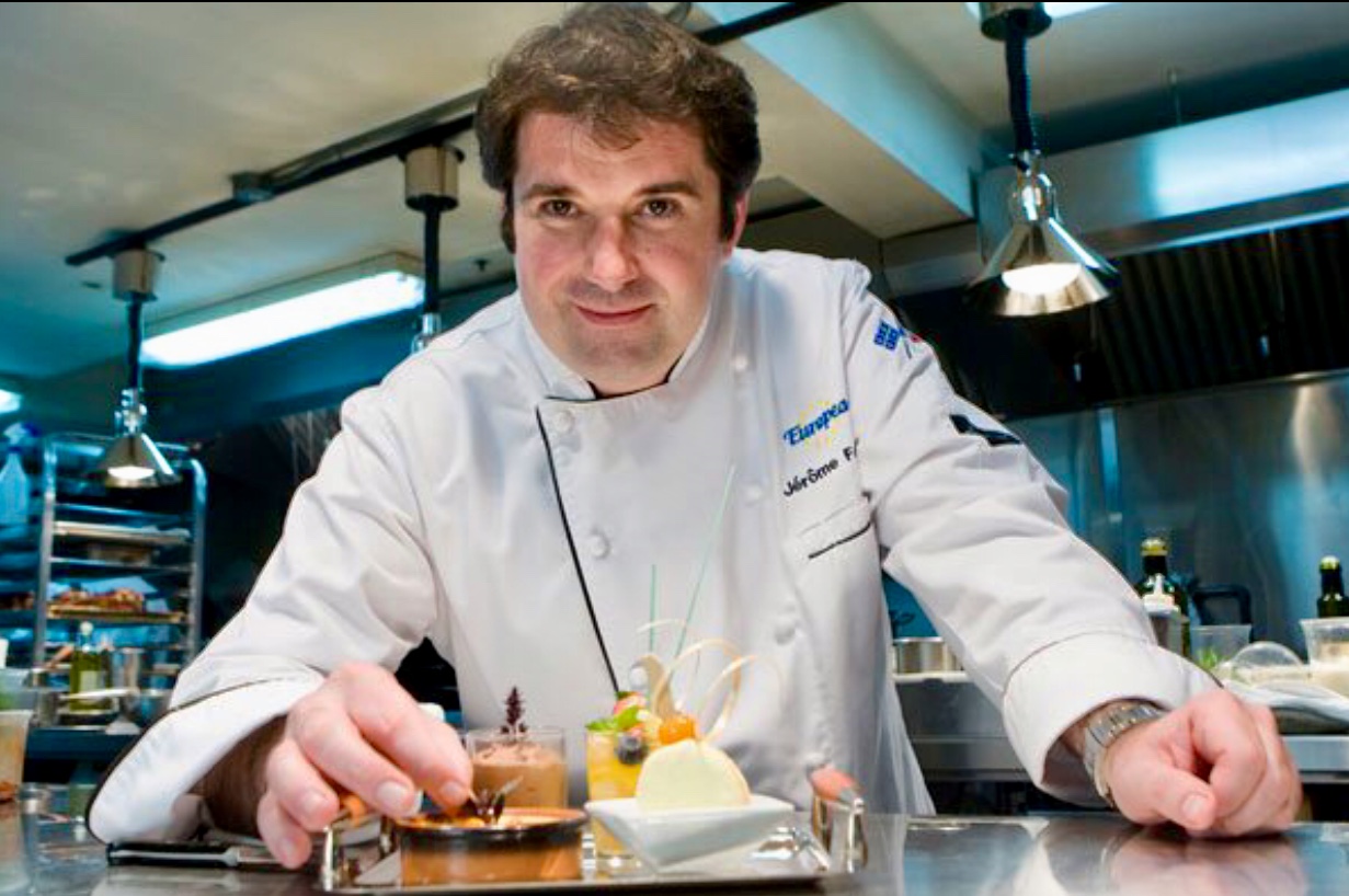 Le chef Jérôme Ferrer prépare un plat dans une cuisine.