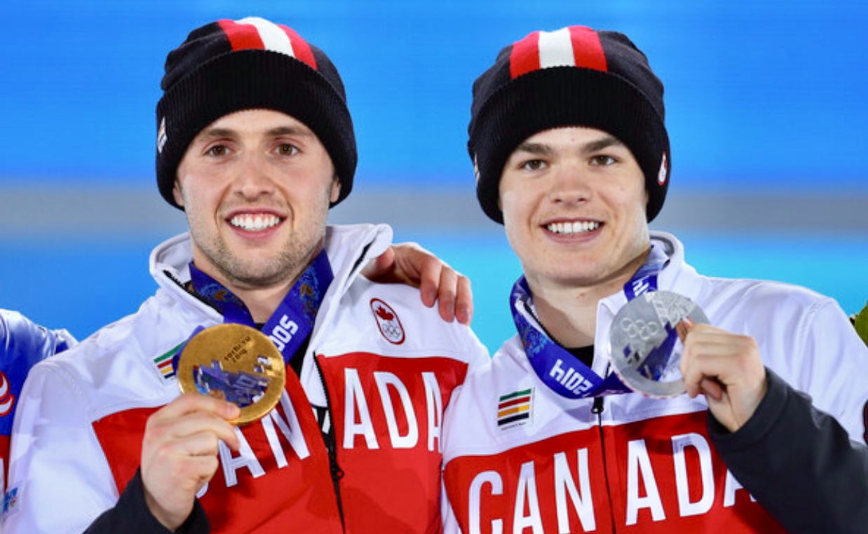Trois joueurs canadiens de hockey sur glace, Alexandre Bilodeau et Mikaël Kingsbury, posent avec leurs médailles.