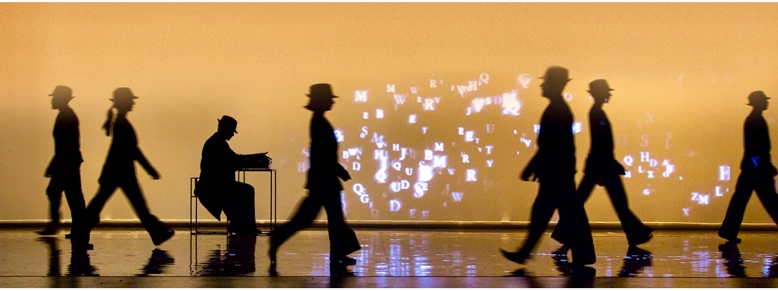 Silhouettes de personnes marchant devant une projection de Leonard Cohen.