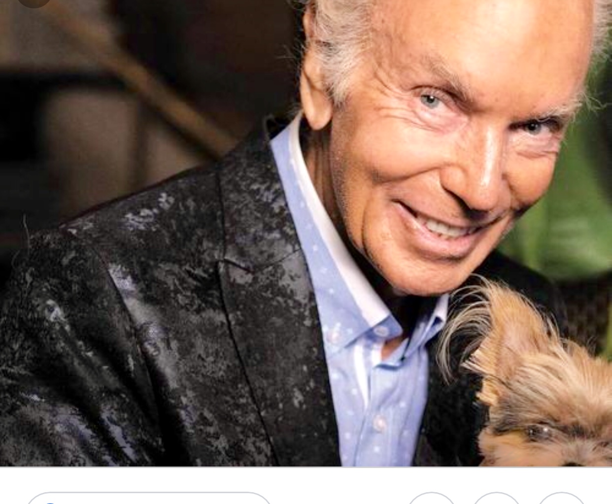 Michel Girouard, un homme plus âgé, tient un petit chien dans ses bras.