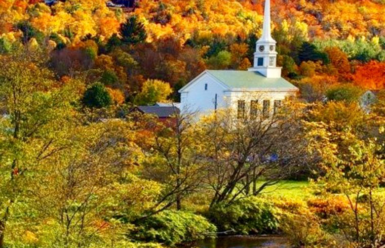 Une église du Vermont est entourée d'arbres et d'une rivière.