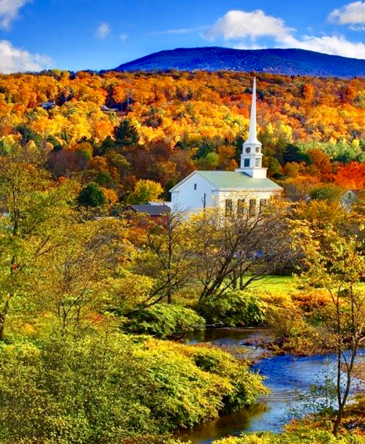 Une église du Vermont est entourée d'arbres et d'une rivière.