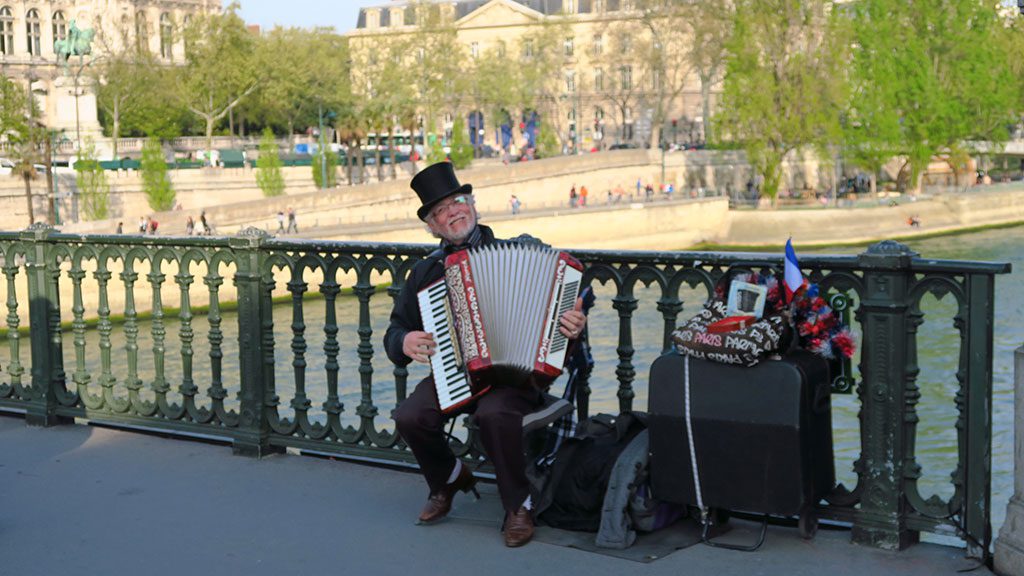 Un homme jouant de l'accordéon près de Notre-Dame de Paris.