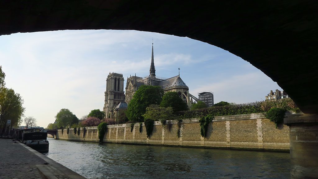 Un pont sur un canal avec la cathédrale Notre-Dame de Paris en arrière-plan.