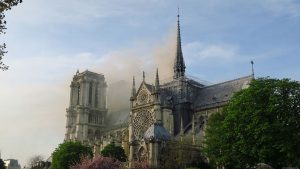 Notre-Dame de Paris, une grande cathédrale d'où sort de la fumée.