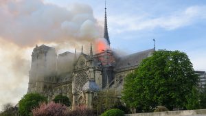 Une célèbre cathédrale, Notre-Dame de Paris, est la proie des flammes et de la fumée s'en échappe.