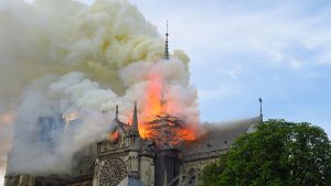 Notre-Dame de Paris, un grand bâtiment d'où sort de la fumée.