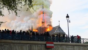 Un groupe de personnes observe un incendie depuis le haut de Notre-Dame de Paris.