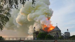 Notre-Dame de Paris, la cathédrale emblématique, est en proie aux flammes et de la fumée s'élève du bâtiment historique.