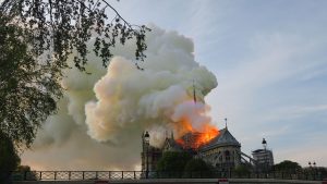 Notre-Dame de Paris, un grand bâtiment avec des siècles d'histoire, est la proie des flammes, projetant une épaisse fumée dans le ciel.