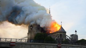 Notre-Dame de Paris, un grand bâtiment d'où sort de la fumée.