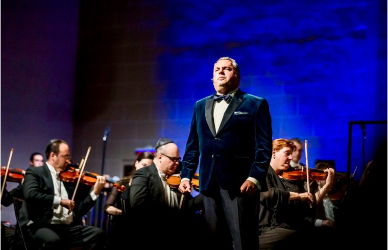 Un homme en smoking, Bernstein, debout devant un orchestre lors d'un concert.