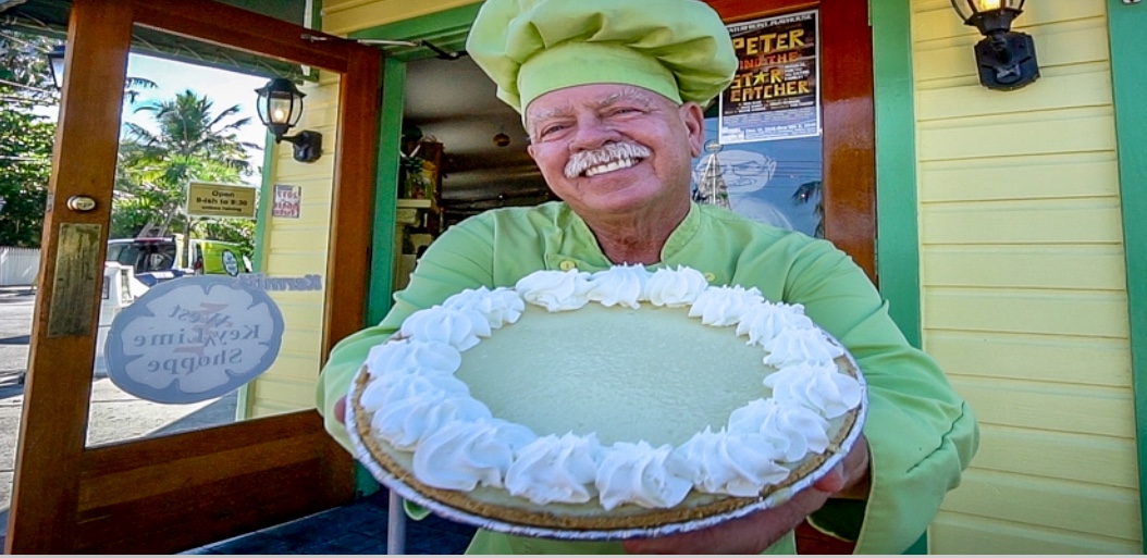 Un homme au chapeau vert tenant une tarte à Key West.