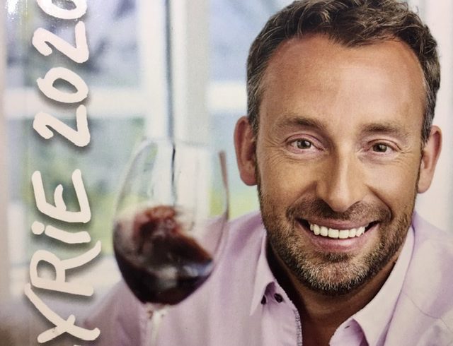 Une photo d'un homme tenant un verre de vin du Lapeyrie 2020.