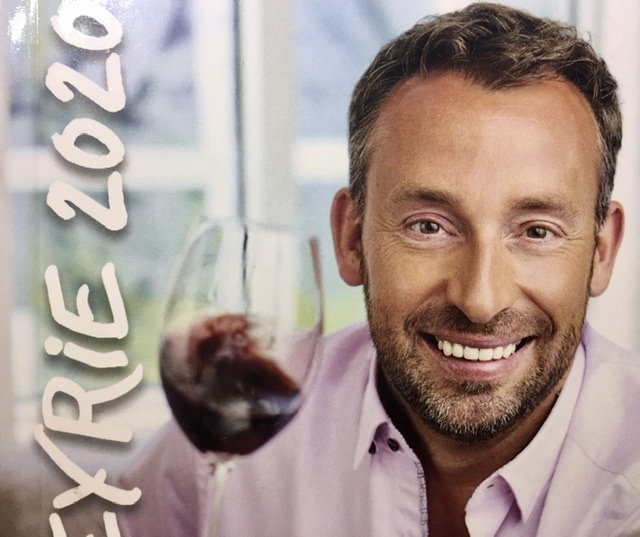 Une photo d'un homme tenant un verre de vin du Lapeyrie 2020.