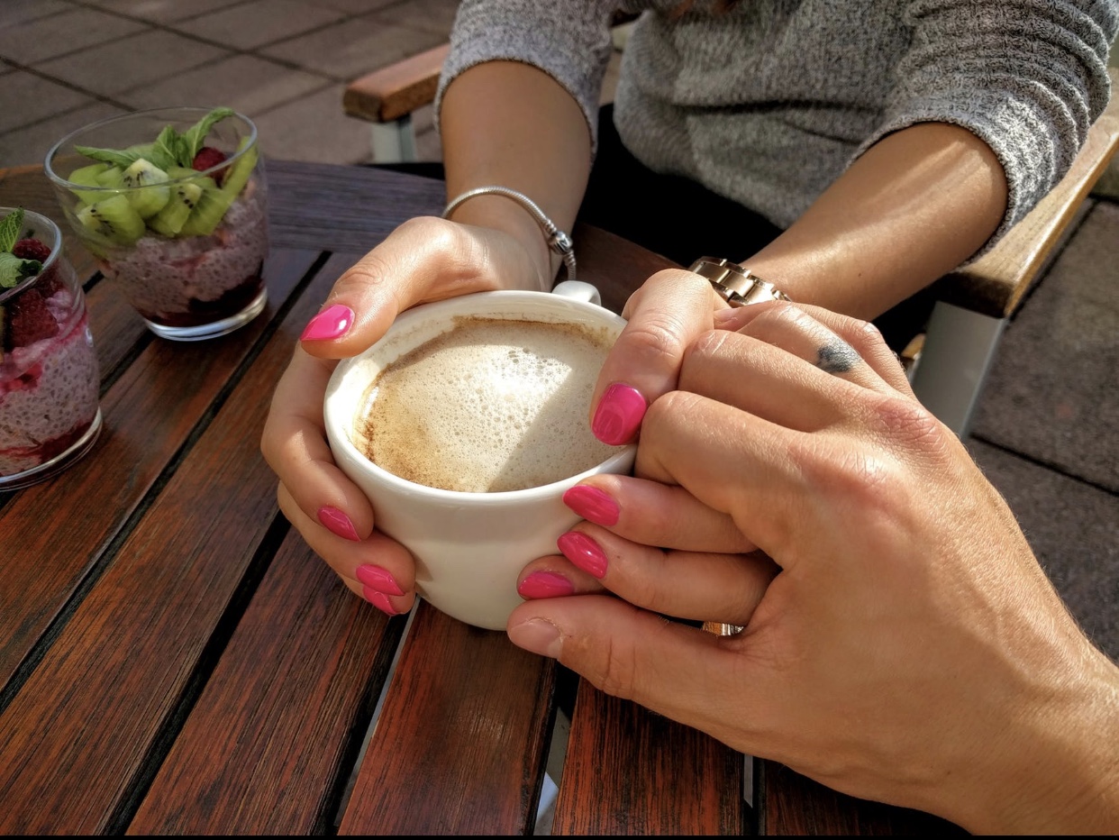 Un couple du Café Melitta se tenant la main et dégustant une tasse de café.