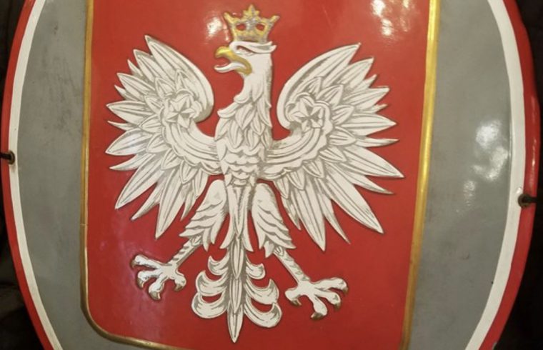 Un écu avec un aigle, représentant la Pologne.