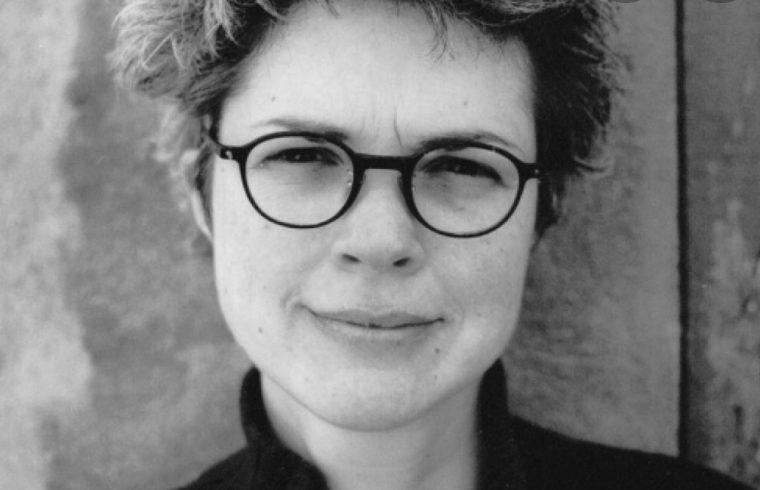 Martine Audet est capturée dans une photo envoûtante en noir et blanc, ses lunettes ajoutant une touche sophistiquée à son style raffiné.