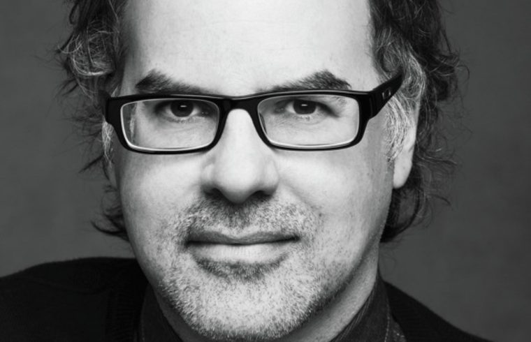 Une photo en noir et blanc de Stéphane Dompiere, un homme portant des lunettes.