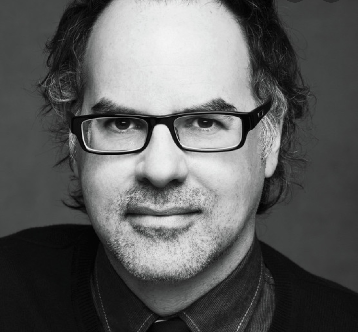 Une photo en noir et blanc de Stéphane Dompiere, un homme portant des lunettes.