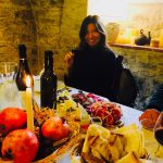 En Italie, une femme est assise à une table avec un panier de nourriture.