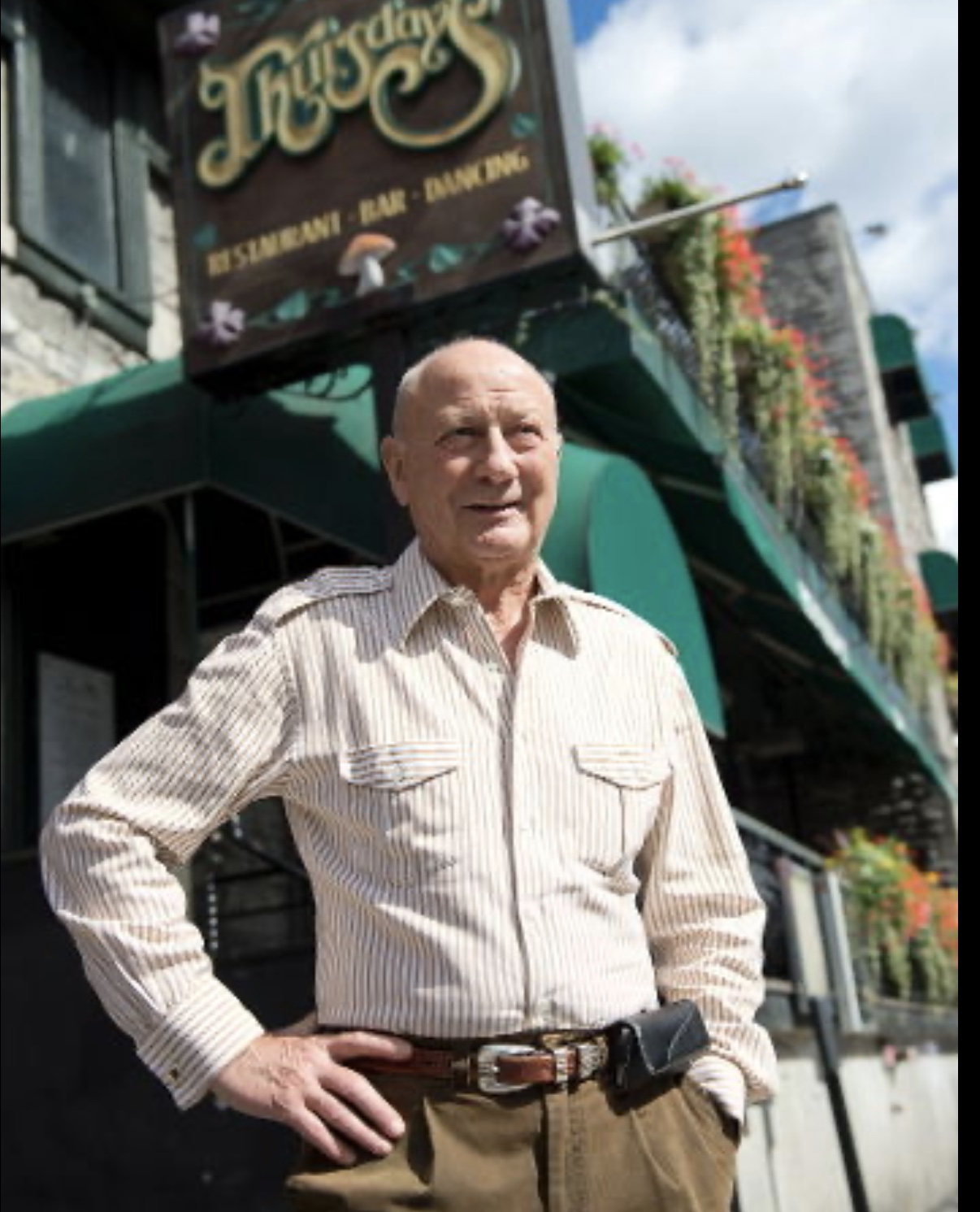 Un homme âgé debout devant un restaurant, marquant la fin d'une époque.