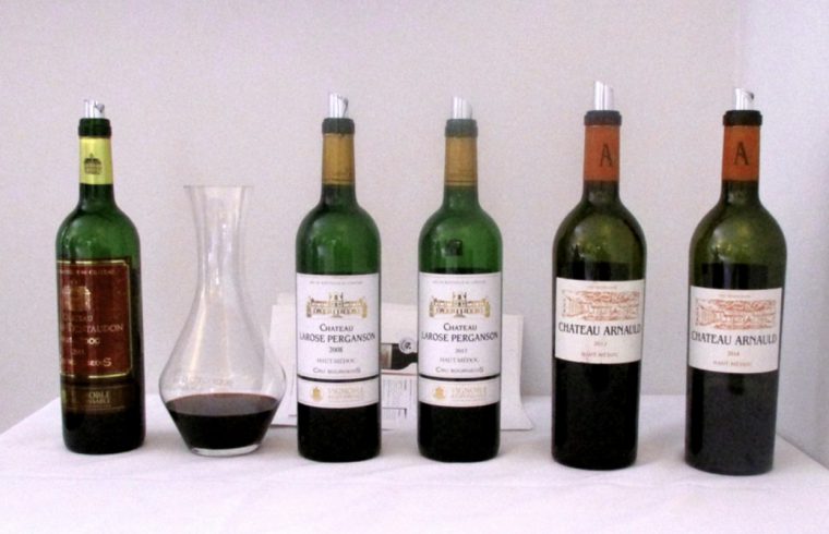 Cinq vins sont alignés sur une table.