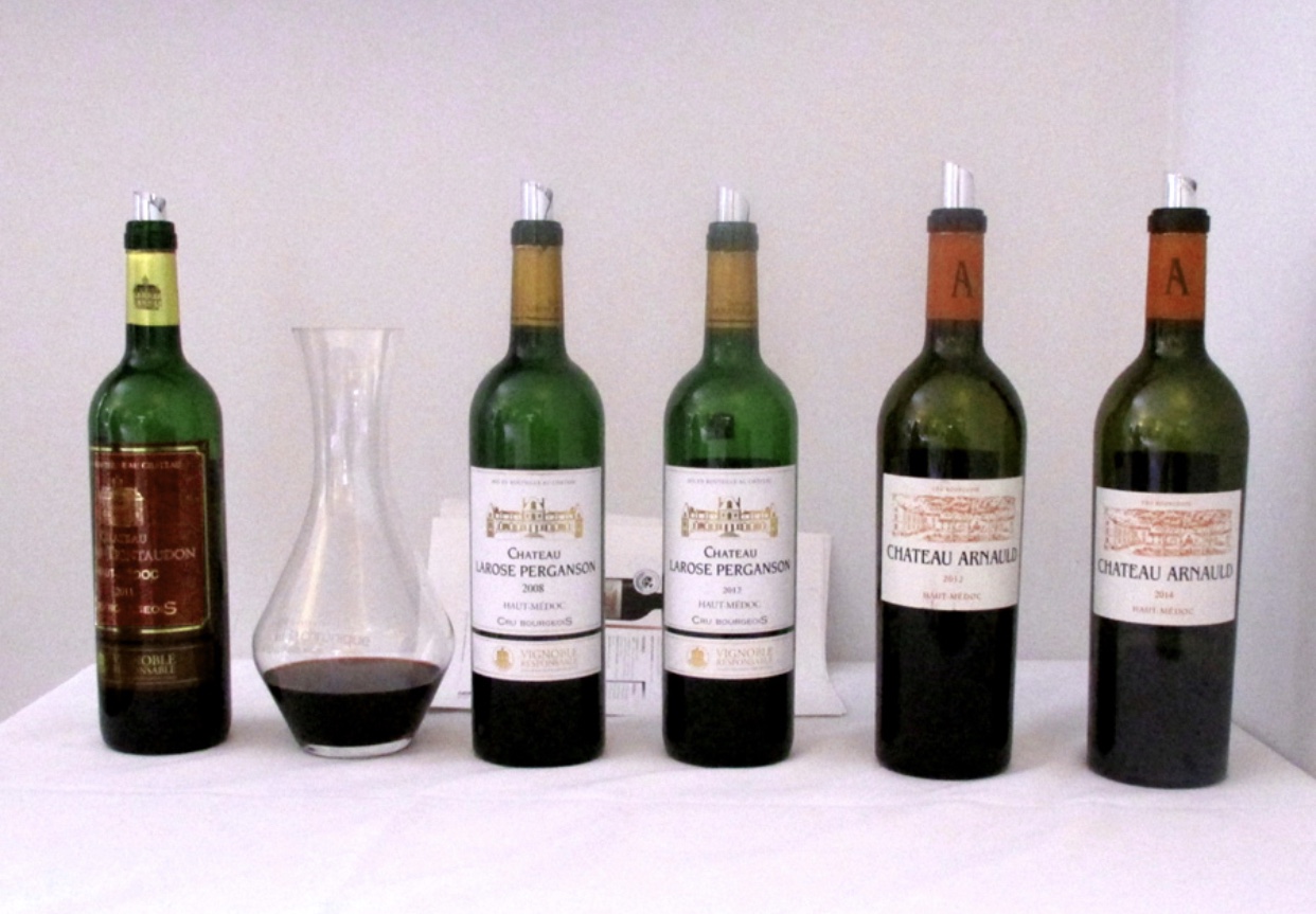 Cinq vins sont alignés sur une table.